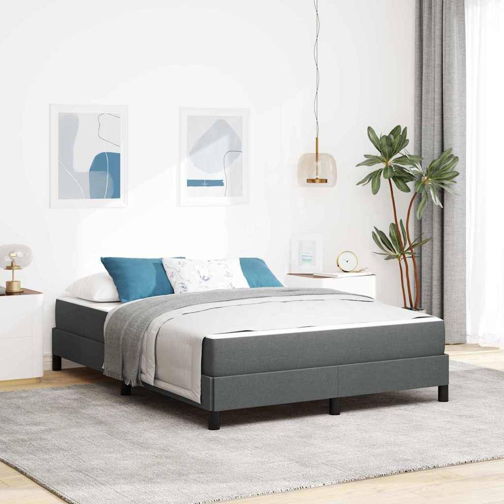 Ein modernes Schlafzimmer mit einem grauen Plattformbett, weiß-blauer Bettwäsche, zwei abstrakten Gemälden, einer Pendelleuchte und einer Zimmerpflanze.