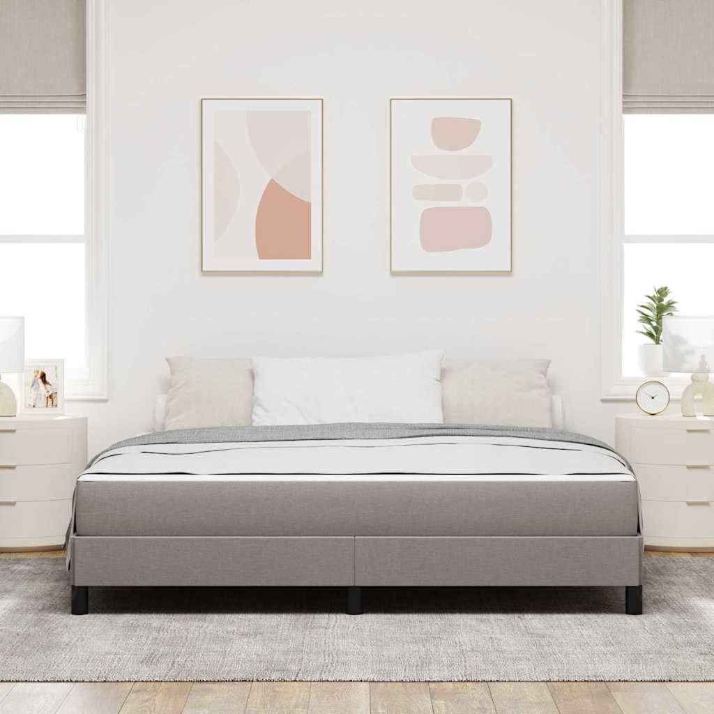 Ein modernes Schlafzimmer mit einem ordentlich gemachten grauen Bett, abstrakter Kunst an den Wänden, zwei Nachttischen mit Lampen und natürlichem Licht von großen Fenstern.