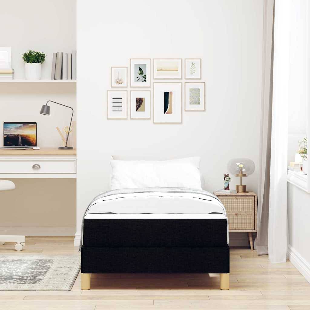 Ein minimalistisches Schlafzimmer mit einem Einzelbett, einem Holznachttisch und einem wandmontierten Schreibtisch. Kunstrahmen und Pflanzen dekorieren den Raum.