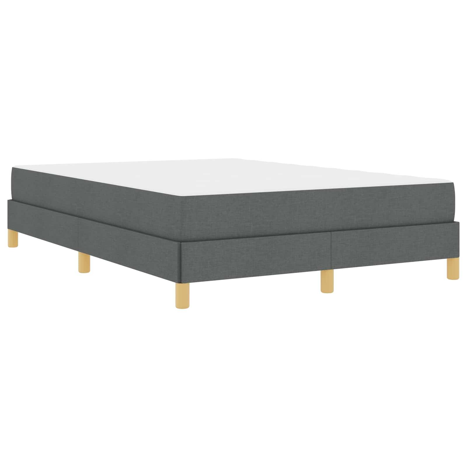 Ein grauer gepolsterter Bettrahmen mit Holzbeinen, der ein einfaches und modernes Design aufweist.