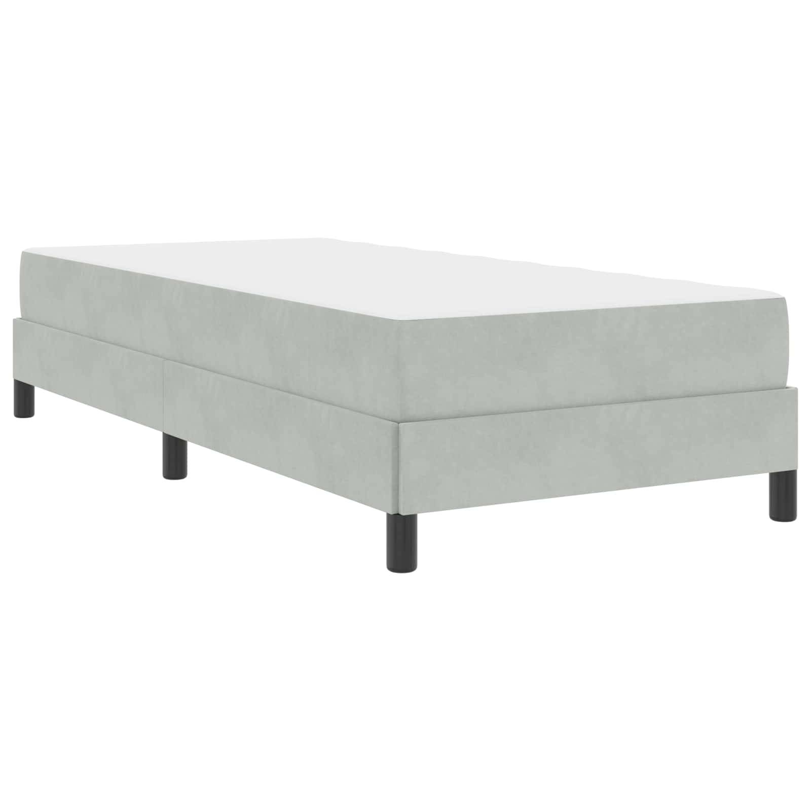 Ein hellgrau gepolsterter Einzelbettrahmen mit schwarzen Beinen, von einem leichten Winkel aus betrachtet, der sein niedriges Profil und minimalistisches Design zeigt.