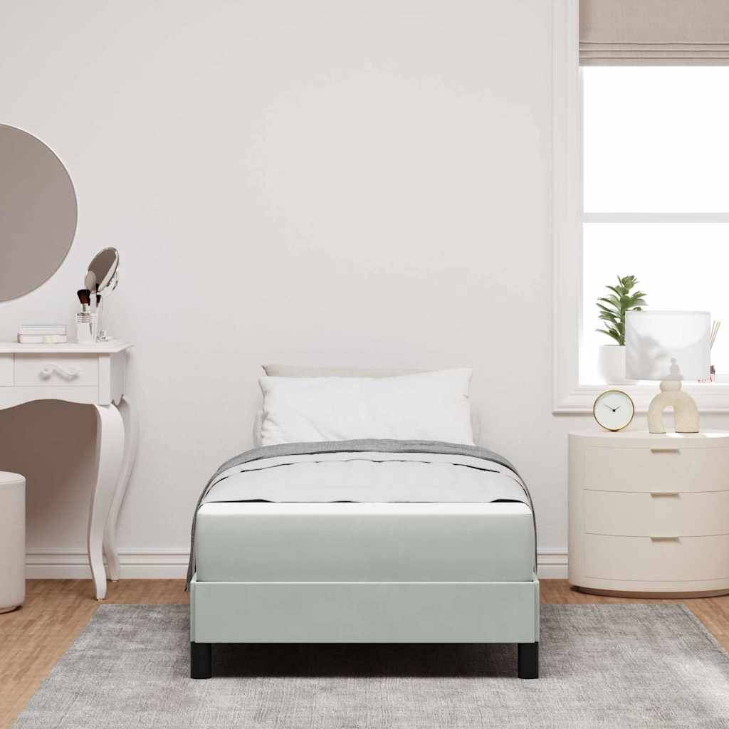 Ein minimalistisches Schlafzimmer zeigt ein Einzelbett mit weißer und grauer Bettwäsche, einen runden Spiegel, eine Toilettentafel und ein Fenster neben einer kleinen Kommode.