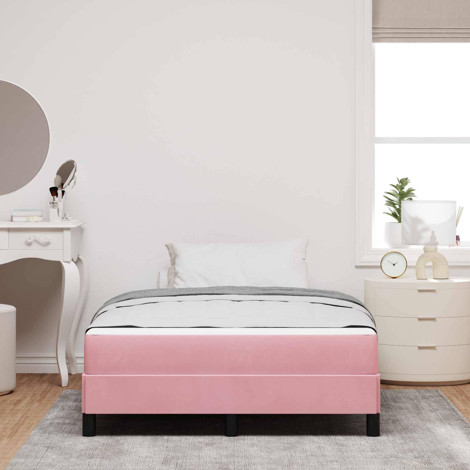 Ein Schlafzimmer mit einem rosa Bett, grauem Teppich und weißen Möbeln, einschließlich eines Frisiertisches und eines runden Spiegels auf der linken Seite sowie einer Kommode am Fenster.
