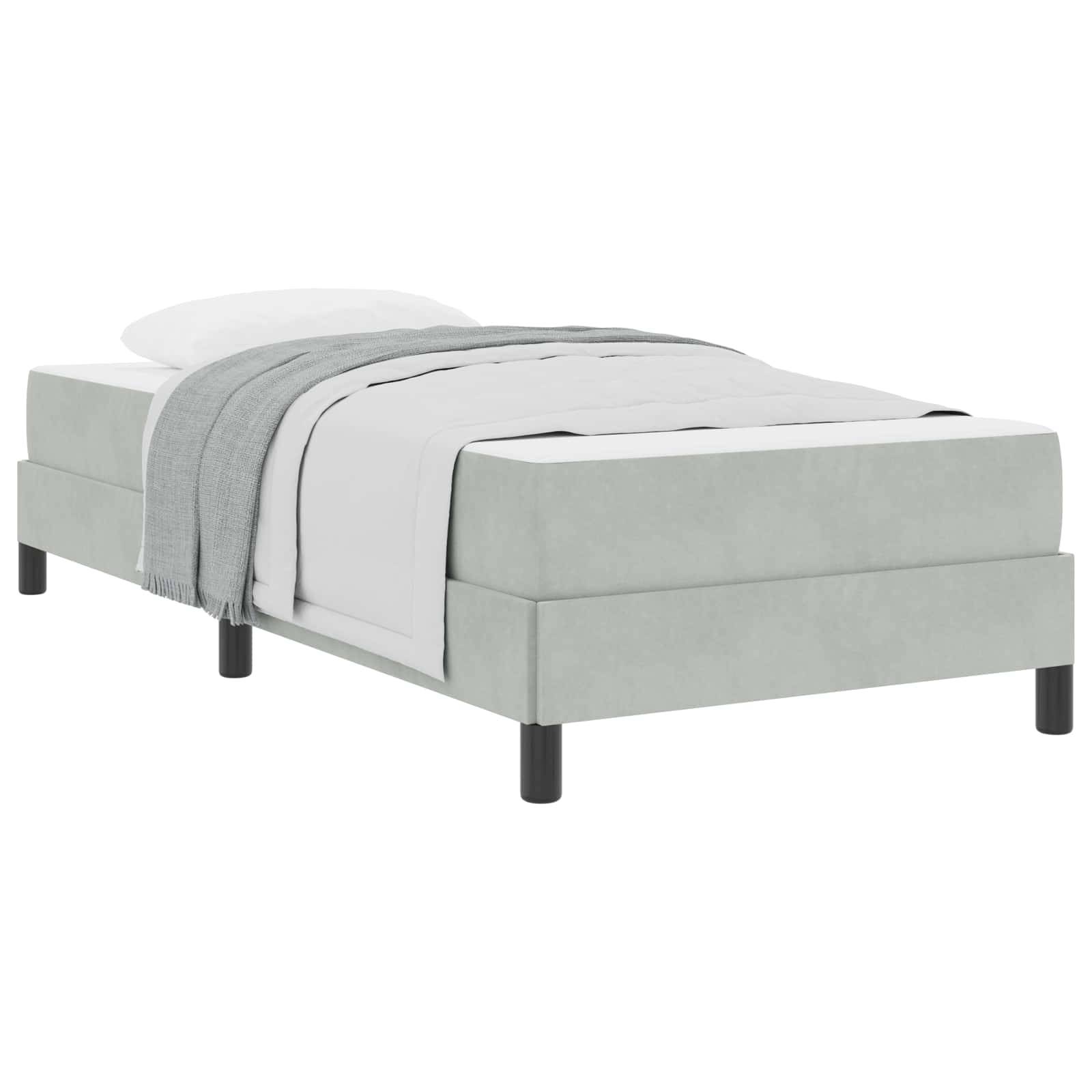 Ein modernes Einzelbett mit einem hellgrauen gepolsterten Rahmen, weißer Bettwäsche und einer passenden grauen Decke, die darüber drapiert ist.