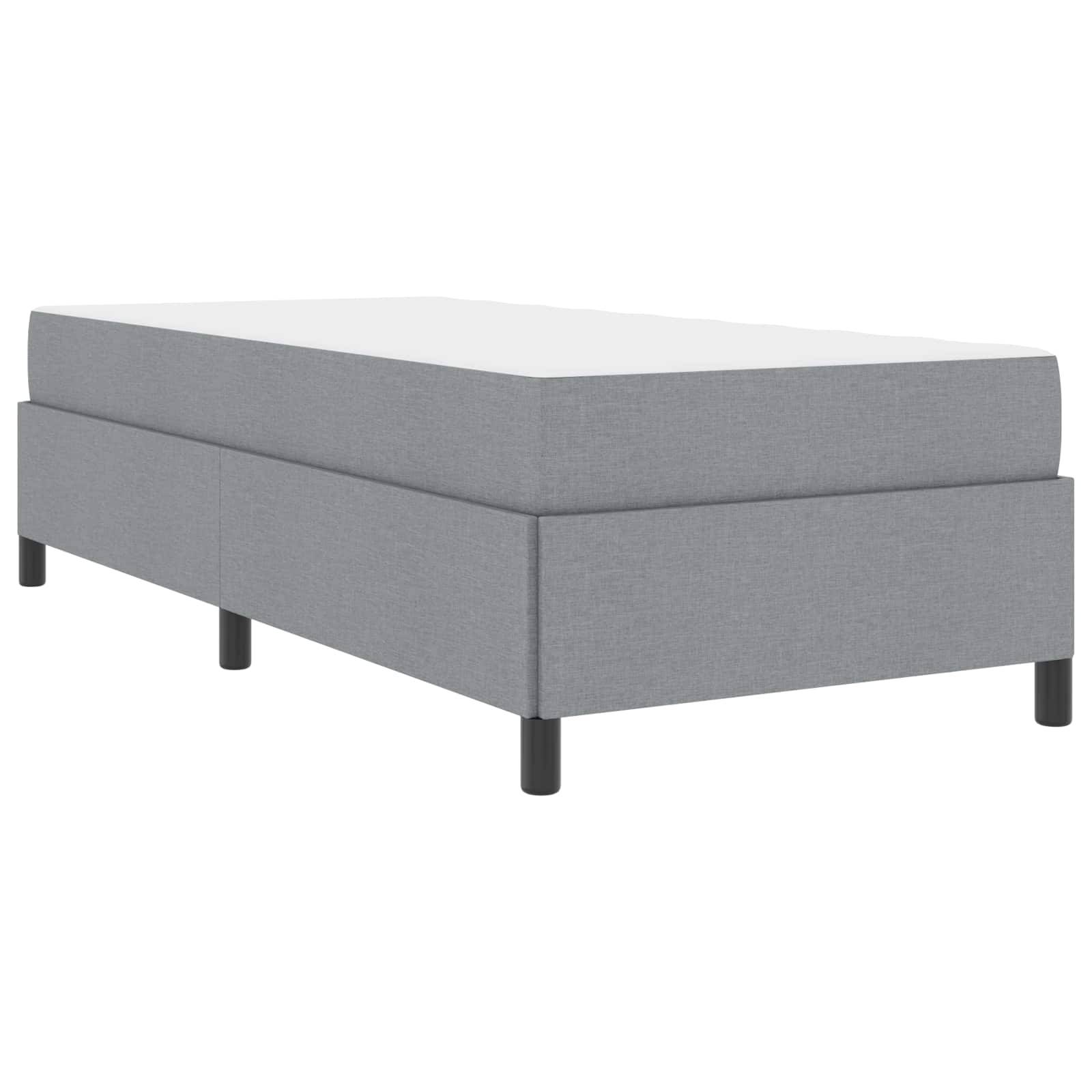 Einfacher grau gepolsterter Einzelbettrahmen mit schwarzen Beinen, ohne Matratze. Minimalistisches Design, passend für moderne Interieurs.