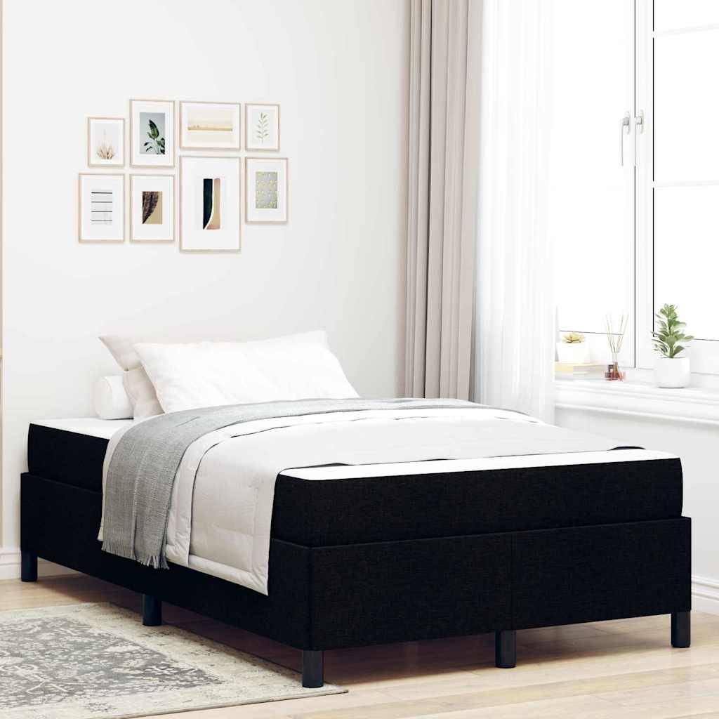 Ein minimalistisches Schlafzimmer mit einem schwarzen Bettgestell, weißer Bettwäsche und einer hellgrauen Decke. Ein Fenster mit transparenten Vorhängen lässt natürliches Licht herein, und kleine gerahmte Kunstwerke schmücken die Wand über dem Bett.