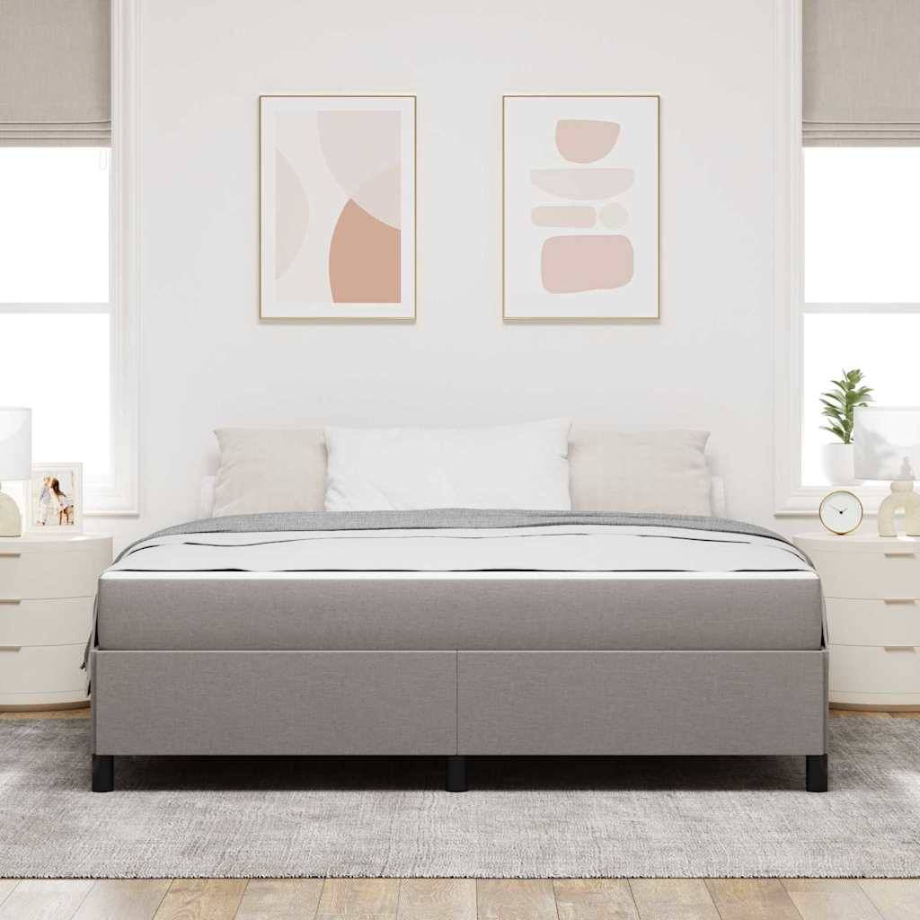 Ein sauber gemachtes Bett mit grauem Rahmen und weißer Bettwäsche, flankiert von weißen Nachttischen mit Lampen. Abstrakte Kunst hängt über dem Bett.