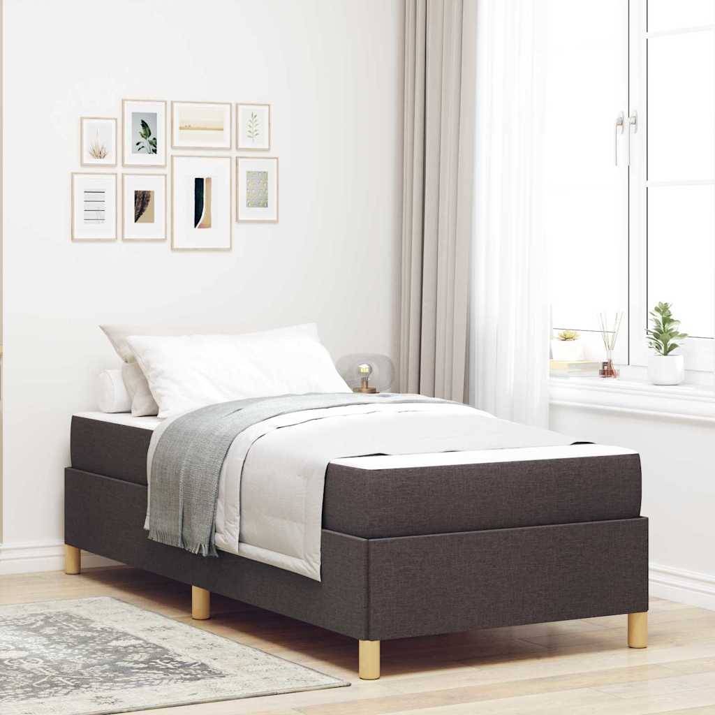 Helles minimalistisches Schlafzimmer mit einem einzelnen dunkel gepolsterten Bett, weißer Bettwäsche, gerahmter Wandkunst und einem Fenster mit transparenten Vorhängen und kleinen Pflanzen.