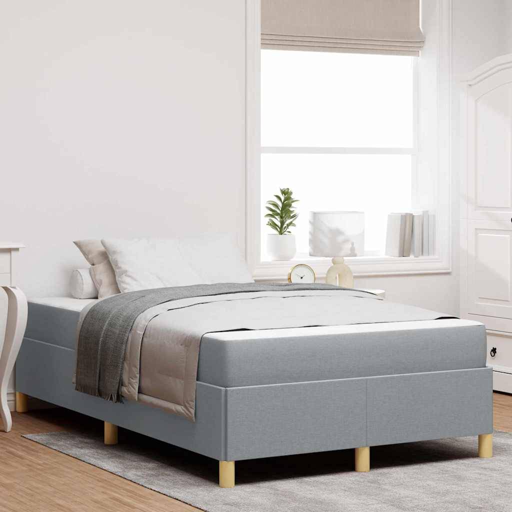 Ein modernes Schlafzimmer verfügt über ein großes Bett mit grauer Bettwäsche, einen Nachttisch mit einer Pflanze und einem Buch sowie ein Fenster mit weichem natürlichem Licht.