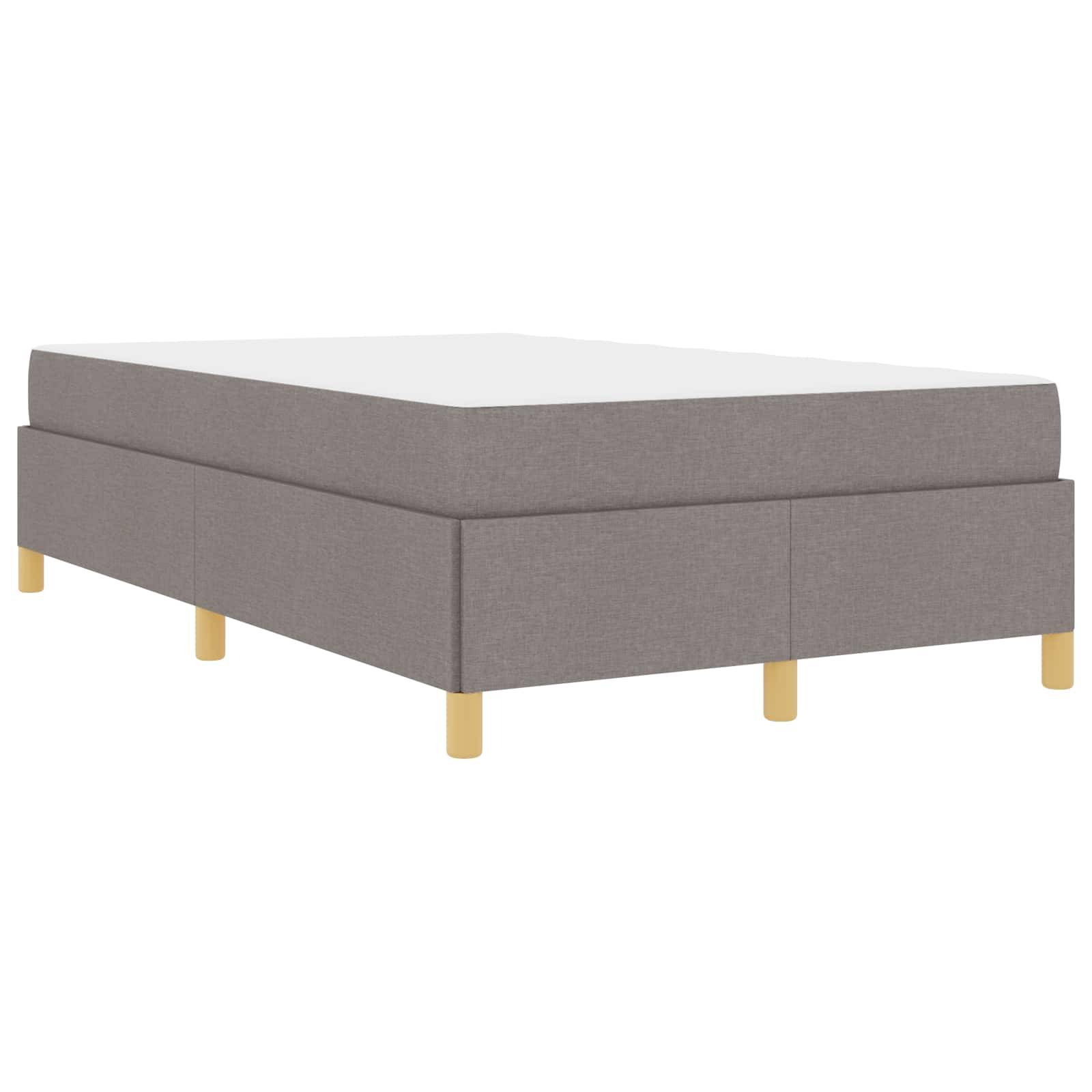Ein grau gepolsterter Bettrahmen mit minimalistischem Design und Holzbeinen, ohne Matratze, vor einem schlichten weißen Hintergrund.