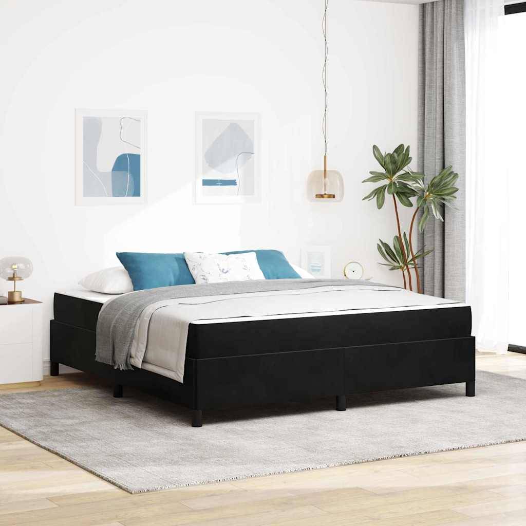 Modernes Schlafzimmer mit schwarzem Podestbett, Teal- und weißen Kissen, grauer Bettwäsche, Wandkunst, einer Topfpflanze und einem hellen Teppich neben einem hellen Fenster.