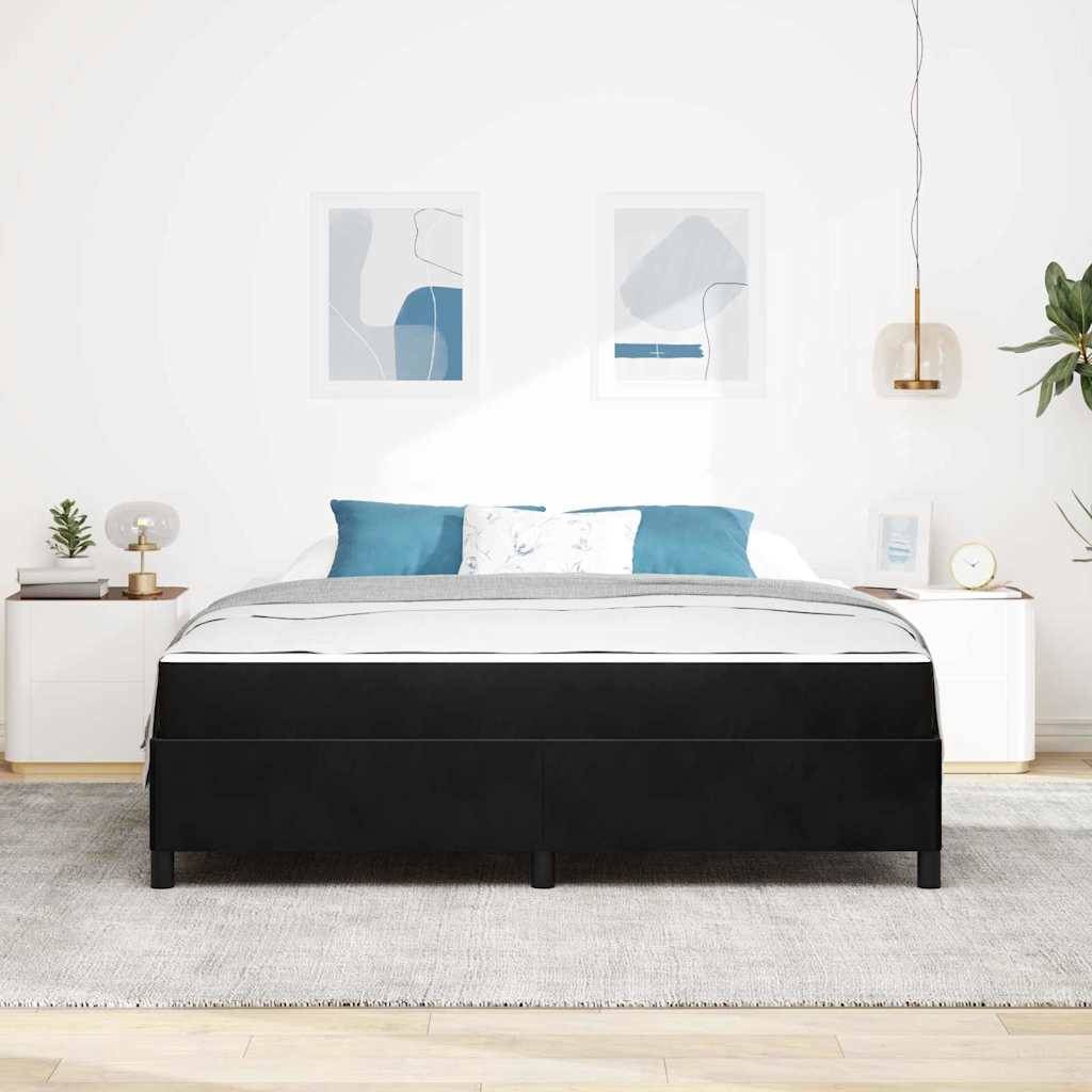 Minimalistisches Schlafzimmer mit einem schwarz gepolsterten Bett, blau-weiß gemusterter Bettwäsche, Nachttischen, gerahmten Wandbildern und einer hängenden Pendelleuchte.