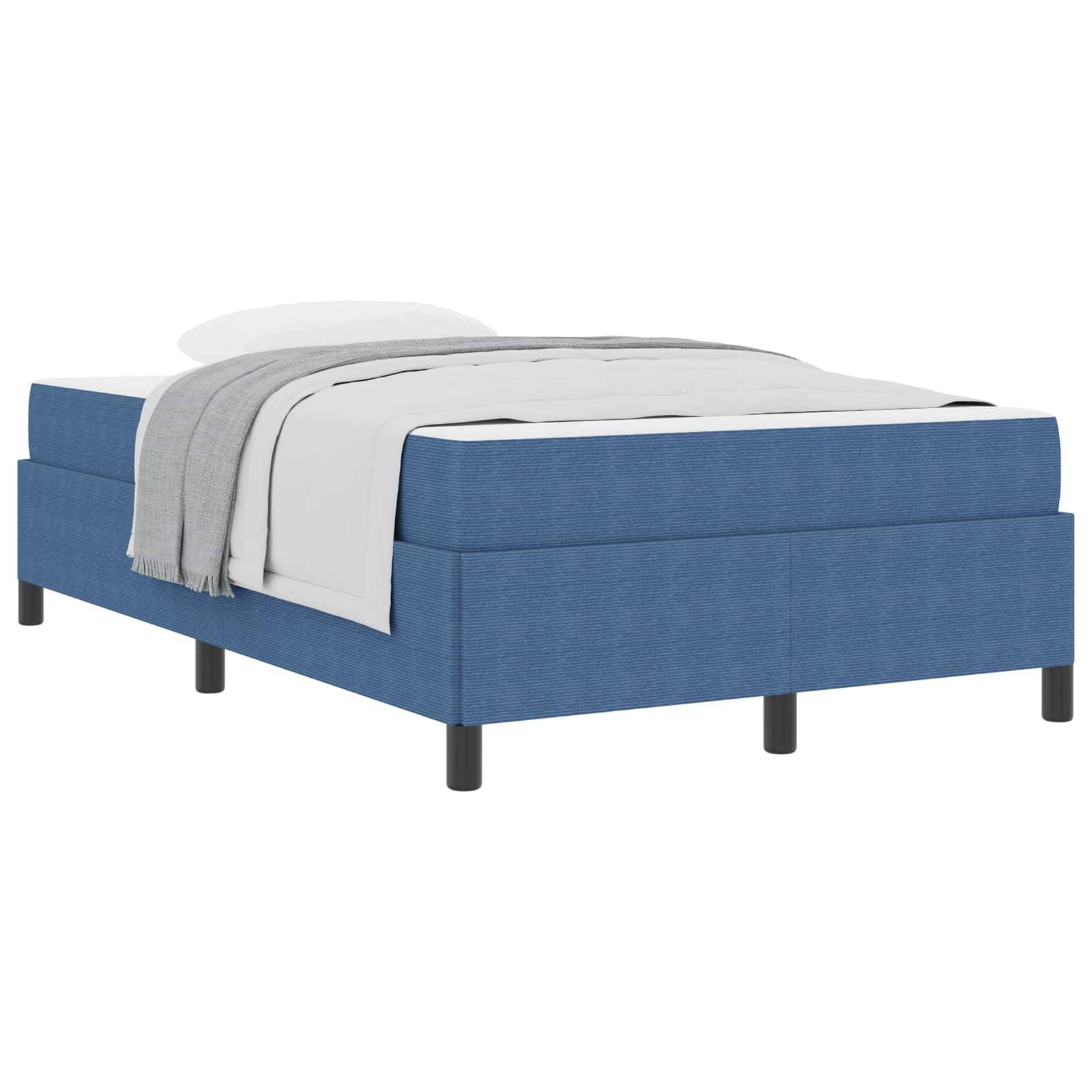 Ein blau gepolstertes Bett mit einer weißen Matratze, einem weißen Kissen und einer grau gefärbten Decke, die teilweise darüber gefaltet liegt; schlichtes und modernes Design.