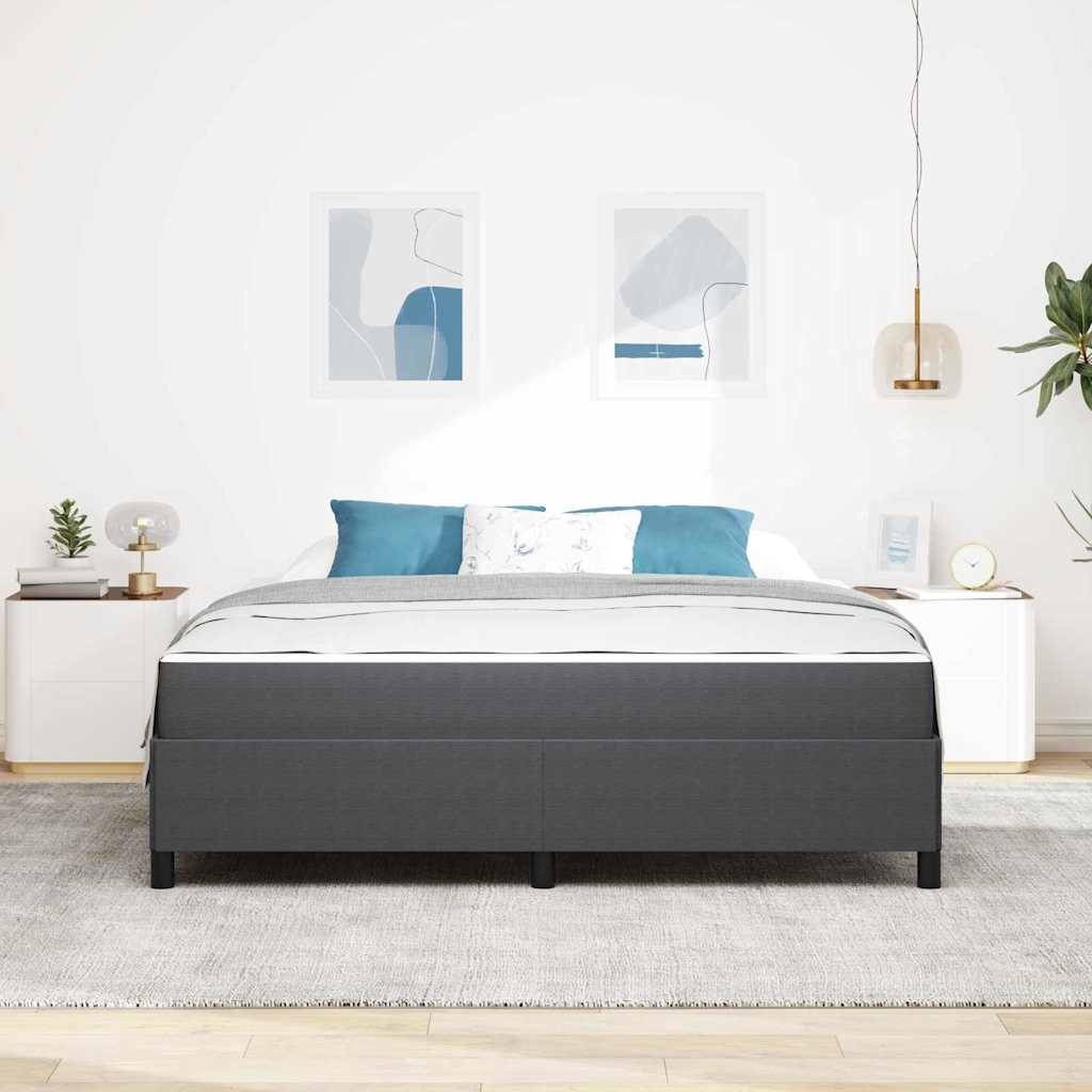 Modernes Schlafzimmer mit einem grau gepolsterten Bett, blau-weißen Kissen, Nachttischen, gerahmter abstrakter Kunst und einer hängenden Pendelleuchte vor einer weißen Wand.