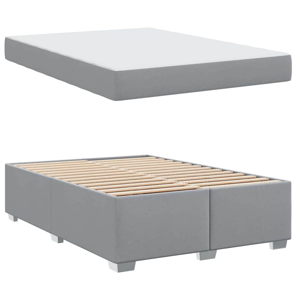 Eine graue Polsterbettbasis mit Latten ist zusammen mit einer passenden grauen Matratze abgebildet. Das Bett ist modern und schlicht in seinem Design.