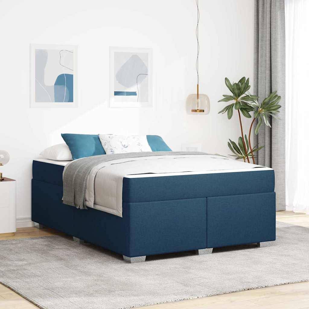 Ein blau gepolstertes Bett mit weißer und grauer Bettwäsche in einem modernen Schlafzimmer. Zwei abstrakte Kunstwerke hängen an der Wand; in der Nähe steht eine Topfpflanze.