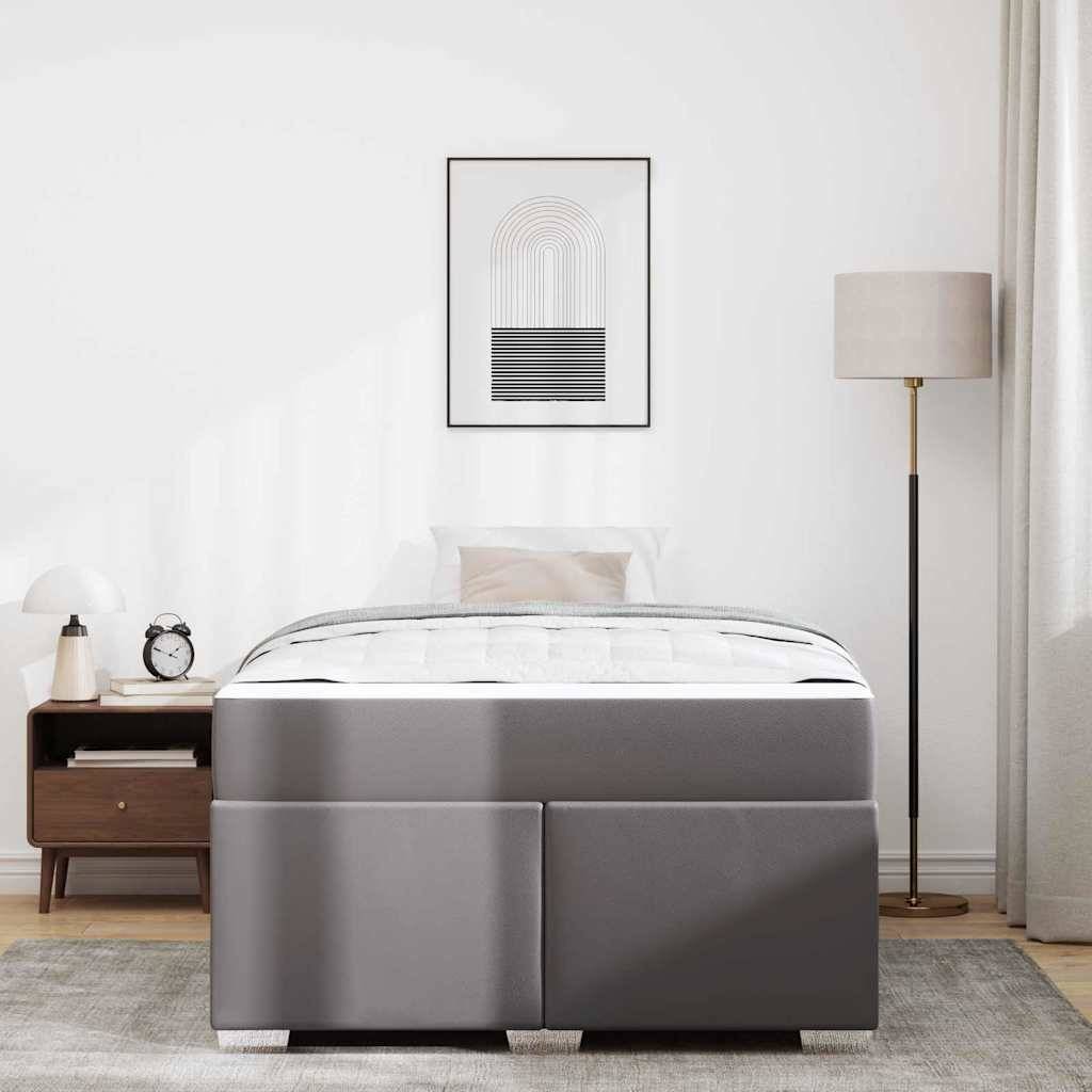 Minimalistisches Schlafzimmer mit einem grau gepolsterten Bett, Nachttisch, Stehleuchte und gerahmtem abstrakten Wandkunstwerk an einer weißen Wand.