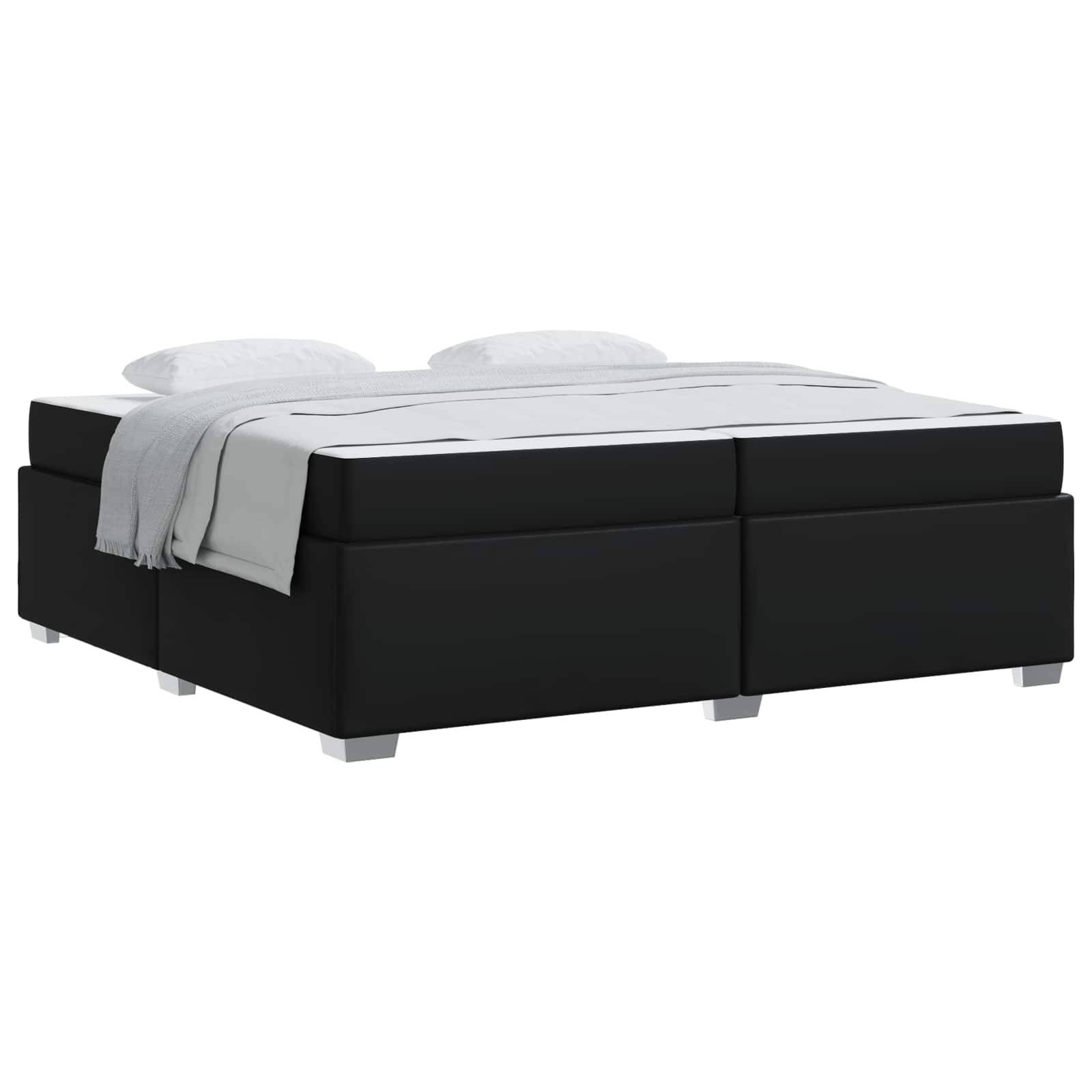 Schwarzes gepolstertes Bett mit weißer Bettwäsche und zwei Kissen auf weißem Hintergrund.