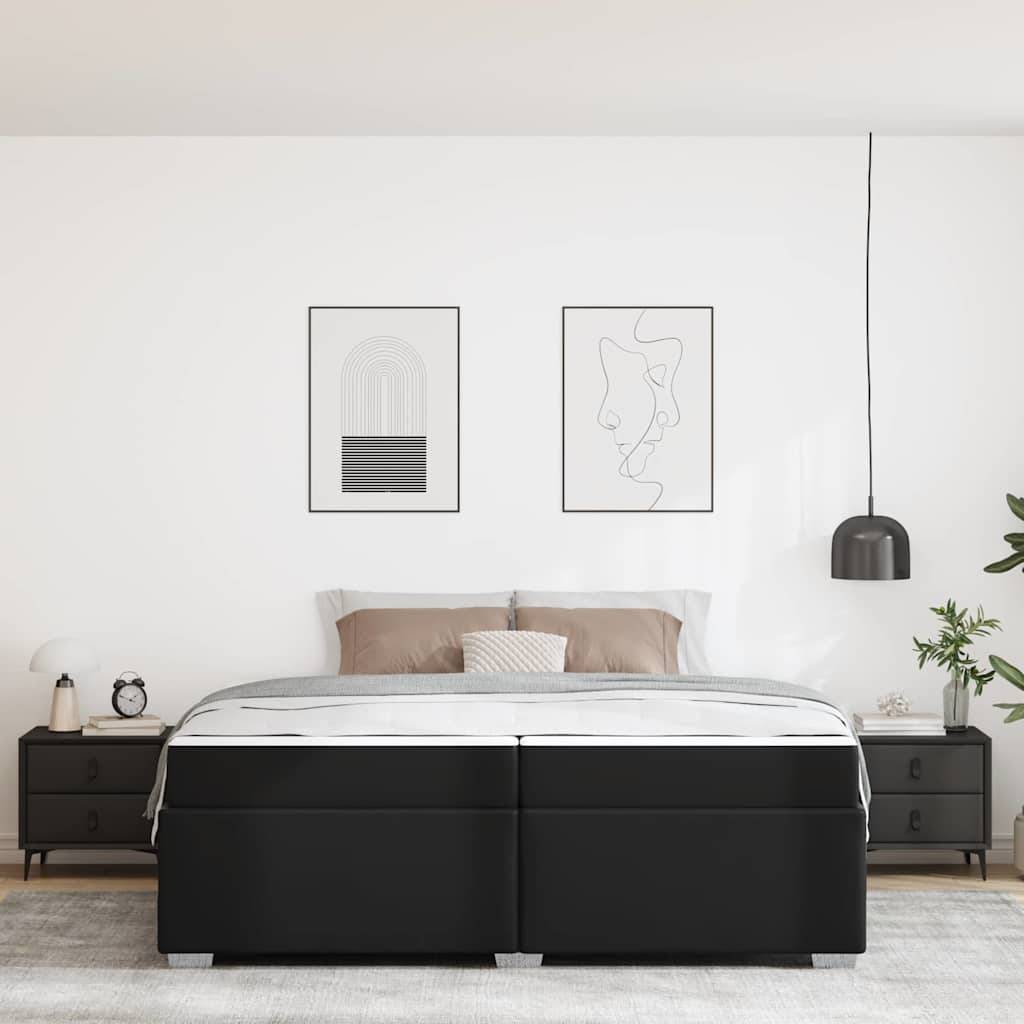 Minimalistisches Schlafzimmer mit einem großen schwarzen Bett in der Mitte zwischen zwei Nachttischen, gerahmter abstrakter Kunst oben und einer hängenden Pendelleuchte auf der rechten Seite.