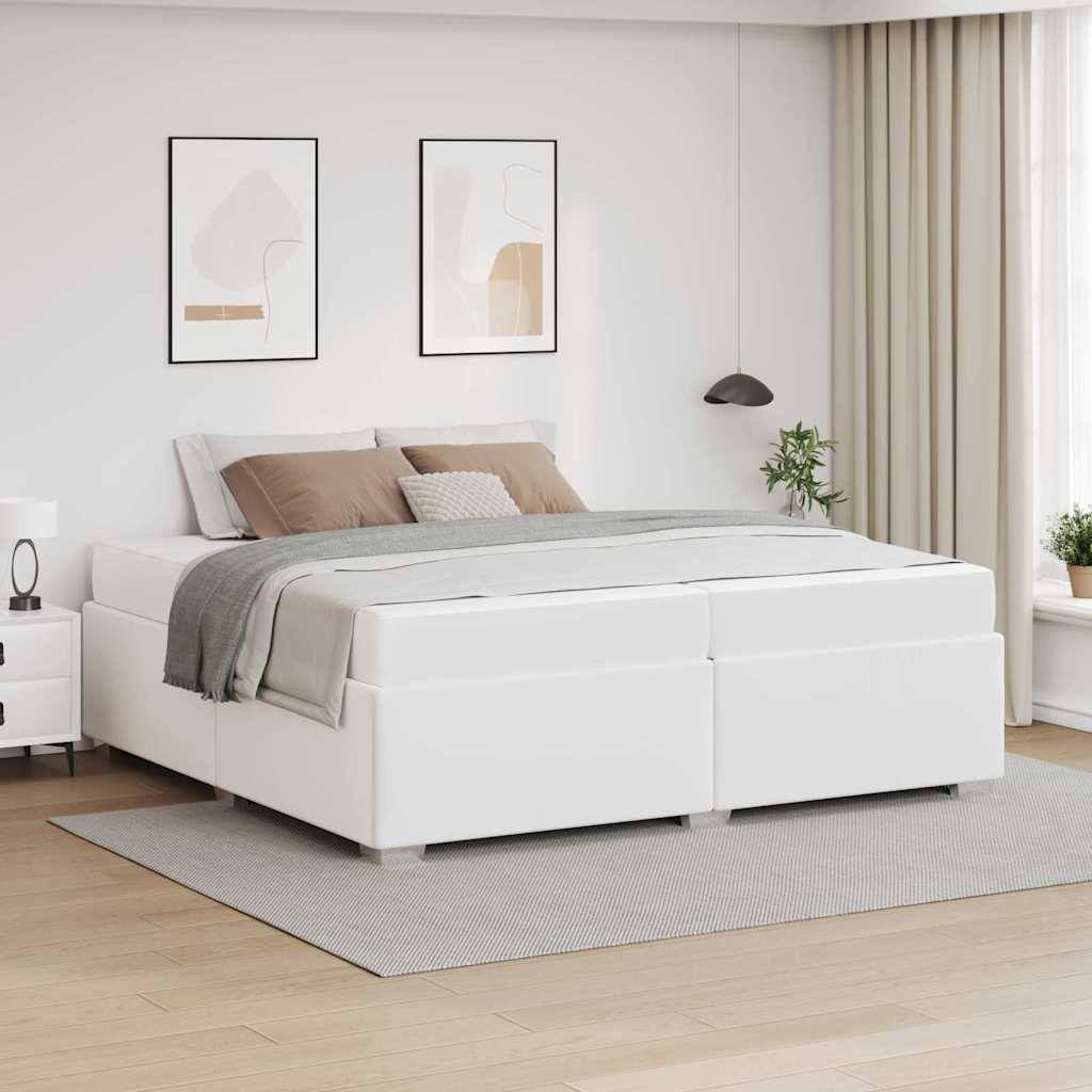 Modernes Schlafzimmer mit einem weiß gepolsterten Bett, grauer Bettwäsche und gerahmten Wandbildern in einem hellen, minimalistischen Interieur.