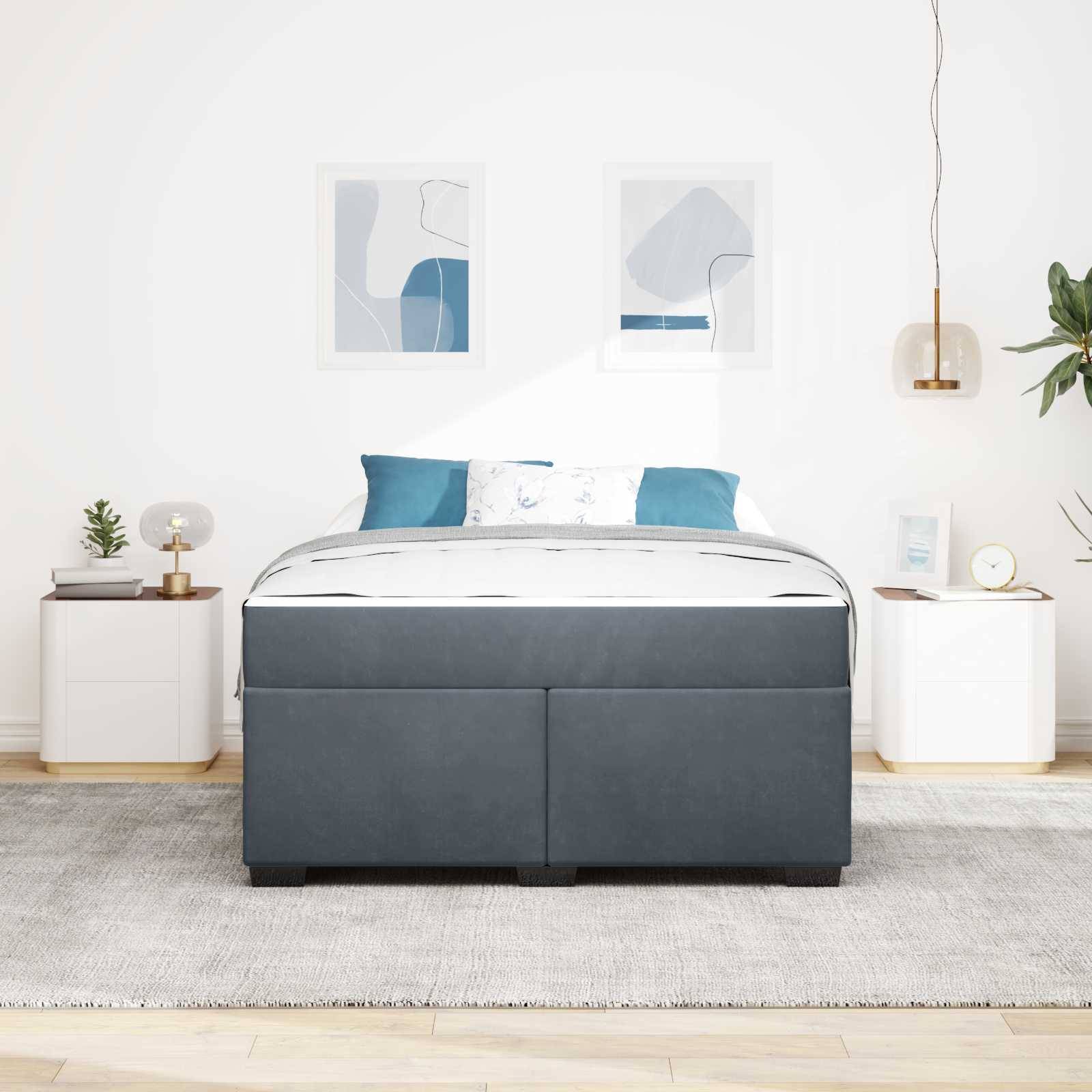 Ein modernes Schlafzimmer zeichnet sich durch ein grau gepolstertes Bett mit blauen Akzentkissen aus, flankiert von weißen Nachttischen, Pendelleuchten und abstrakter Kunst.