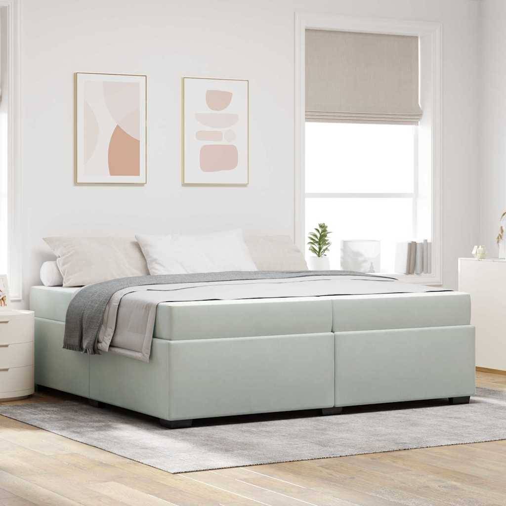 Helles Schlafzimmer mit einem weichen grauen Bett, abstrakten Kunstwerken an den Wänden, großen Fenstern und einer kleinen Pflanze auf dem Nachttisch, die eine ruhige Atmosphäre schafft.
