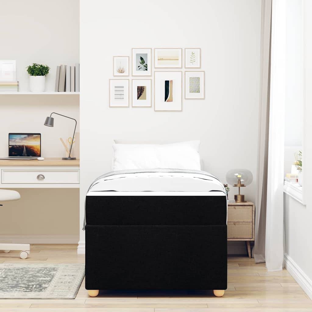 Ein minimalistisches Schlafzimmer mit einem Bett, einem Nachttisch, einer Lampe, einem Schreibtisch und einem Stuhl. Gerahmte Kunstwerke und Pflanzen schmücken die Wände und Regale und schaffen einen ruhigen, modernen Raum.