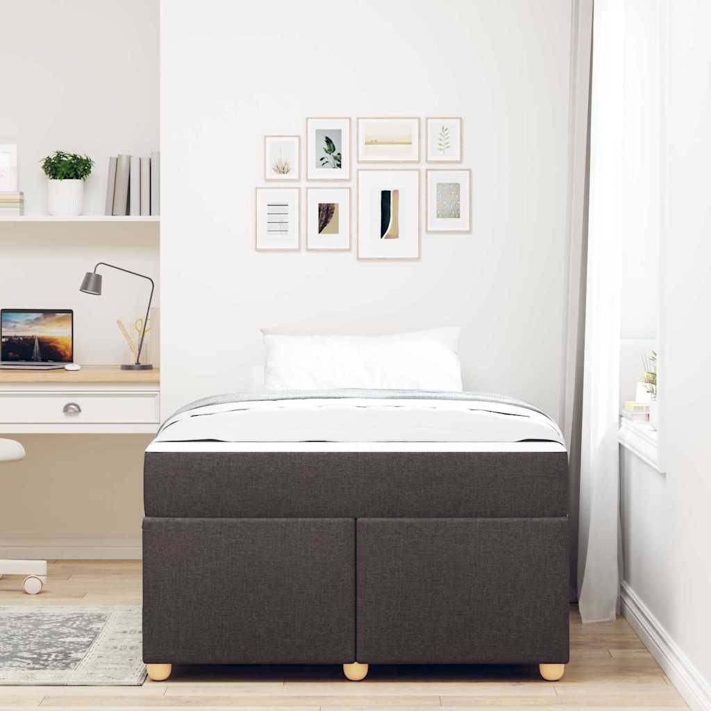 Minimales Schlafzimmer mit einem dunkelgrauen Stauraumbett, weißer Bettwäsche, Wandkunst und einem eingebauten Schreibtisch mit Laptop und Lampe.
