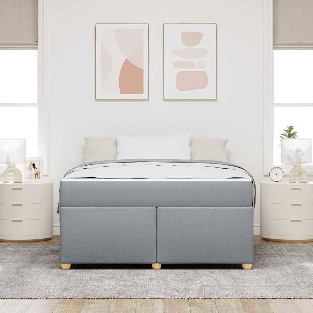 Modernes Schlafzimmer mit einem grau gepolsterten Bett, flankiert von passenden Nachttischen, unter zwei abstrakten gerahmten Drucken.