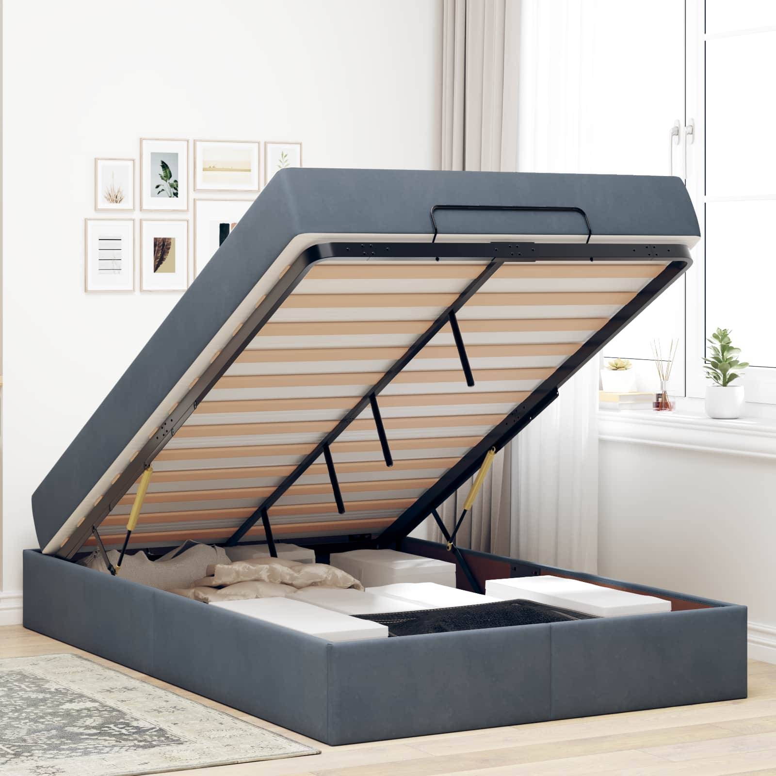 Ein graues Speicherbett mit offener hydraulischer Hebevorrichtung zeigt einen geräumigen Stauraum unter dem Bett, der mit verschiedenen Kartons und Gegenständen in einem hellen Schlafzimmer gefüllt ist.