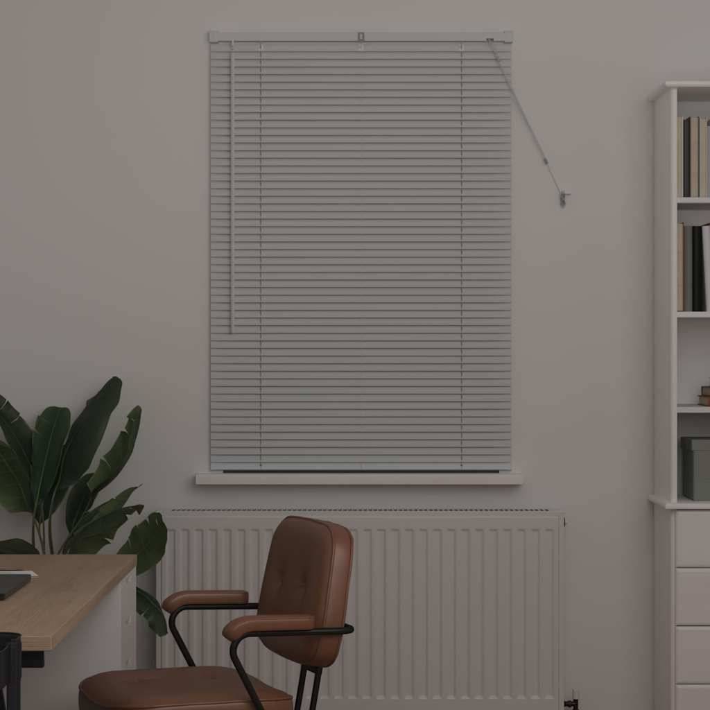 Ein Raum mit einem Fenster, das von Jalousien verdeckt ist, eine Pflanze neben einem Holzstuhl und ein teilweise sichtbares Bücherregal, was auf einen Arbeitsbereich hinweist.
