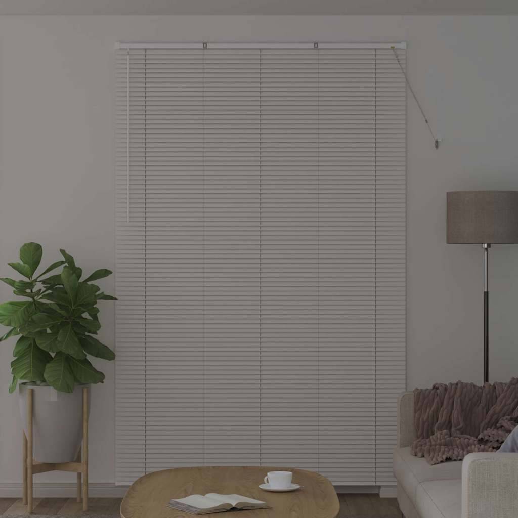 Ein Wohnzimmer mit heruntergelassener Fensterjalousie, einer Zimmerpflanze im Topf, einem Couchtisch und einem Sofa mit einer Lampe daneben, das eine gemütliche Atmosphäre schafft.