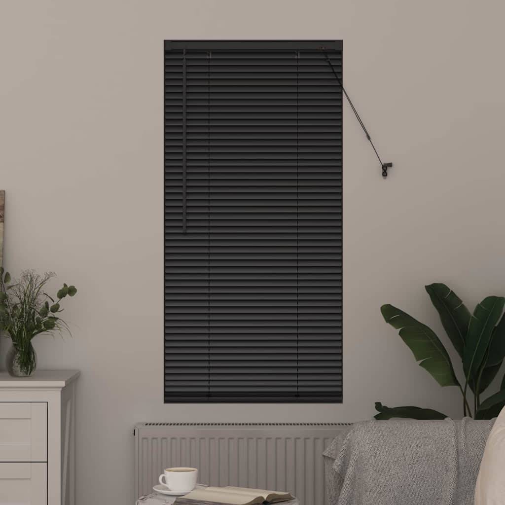 Ein Zimmer mit geschlossenen schwarzen Jalousien, eine weiße Kommode mit einer kleinen Pflanze, eine Pflanze neben einem Sessel, und eine weiße Tasse auf einer Untertasse.