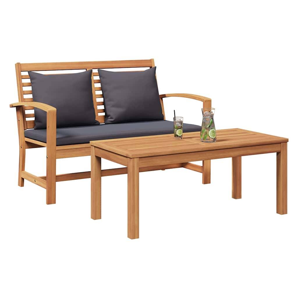Holz-Outdoor-Sitzgarnitur mit einer Bank und einem Tisch, versehen mit grauen Kissen und zwei Gläsern Zitronenlimonade mit Limettenscheiben auf dem Tisch.
