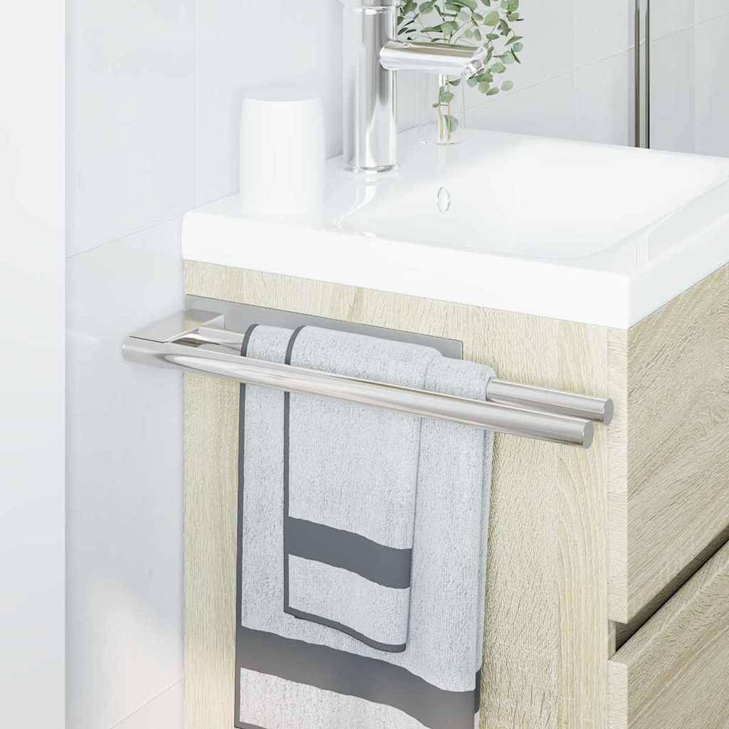 Ein modernes Badezimmerbecken mit einem silbernen Wasserhahn und einem Holzschrank darunter. Ein Handtuch ist ordentlich über einer Schiene drapiert, die am Schrank befestigt ist.