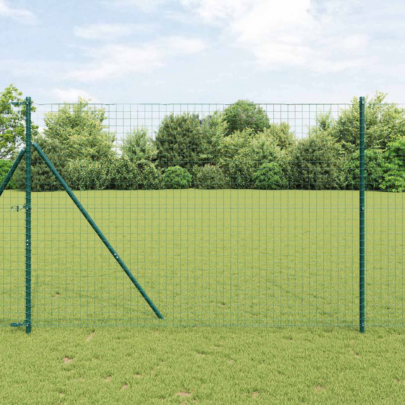 Ein grüner Maschendrahtzaun steht auf einem grasigen Feld, mit einem Hintergrund aus dichten Bäumen und einem klaren Himmel.