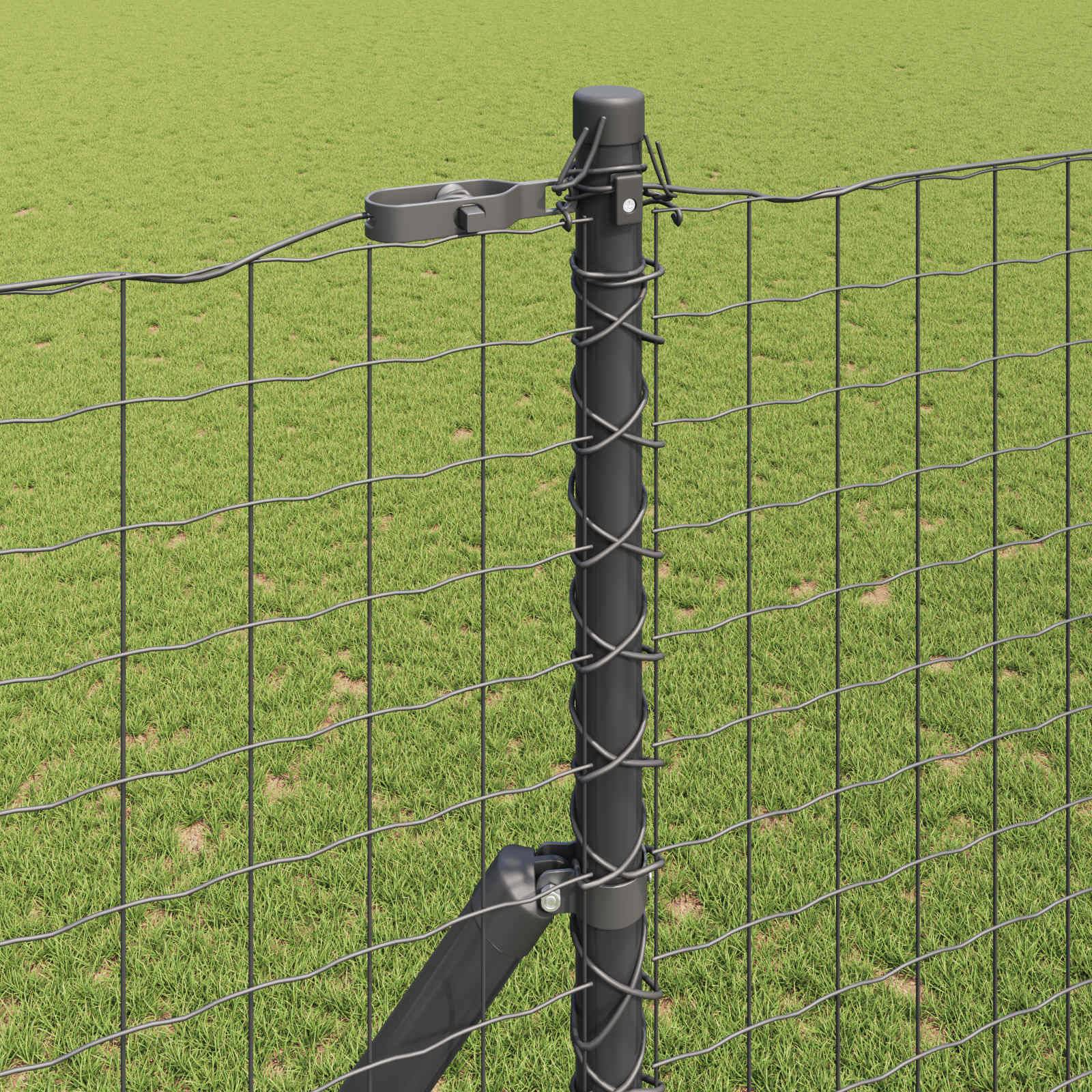 Ein Drahtgatter mit einem schwarzen Metallpfosten steht auf grasigem Boden. Der Pfosten hat Clips, die die Gatterstränge sichern. Im Hintergrund ist ein offenes Grasfeld zu sehen.