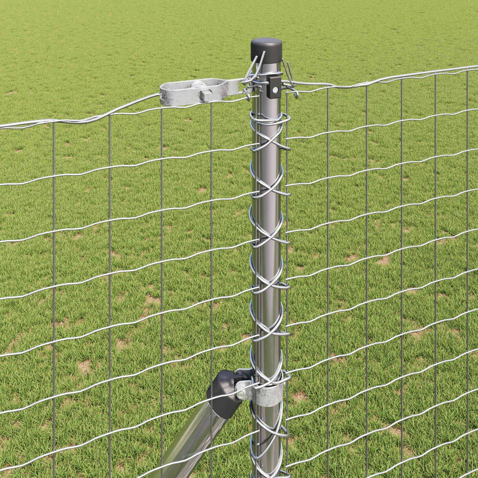Ein Zaunpfosten aus Metall mit Maschendraht in einem Grasfeld.