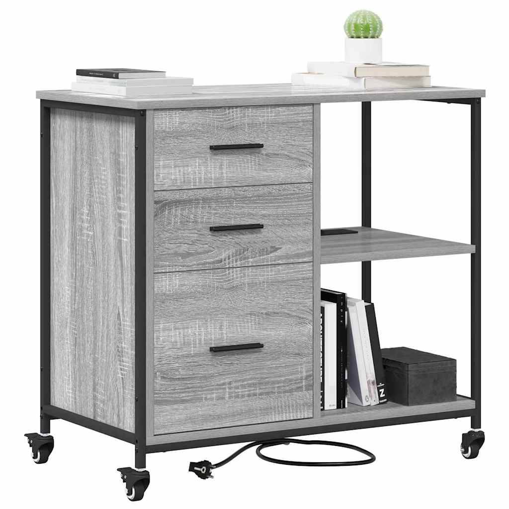 Ein grauer Holz-Rollschreibtisch mit drei Schubladen, einem offenen Regal und einem Metallgestell auf Rollen, auf dem Bücher, eine Pflanze und ein Notizbuch platziert sind.
