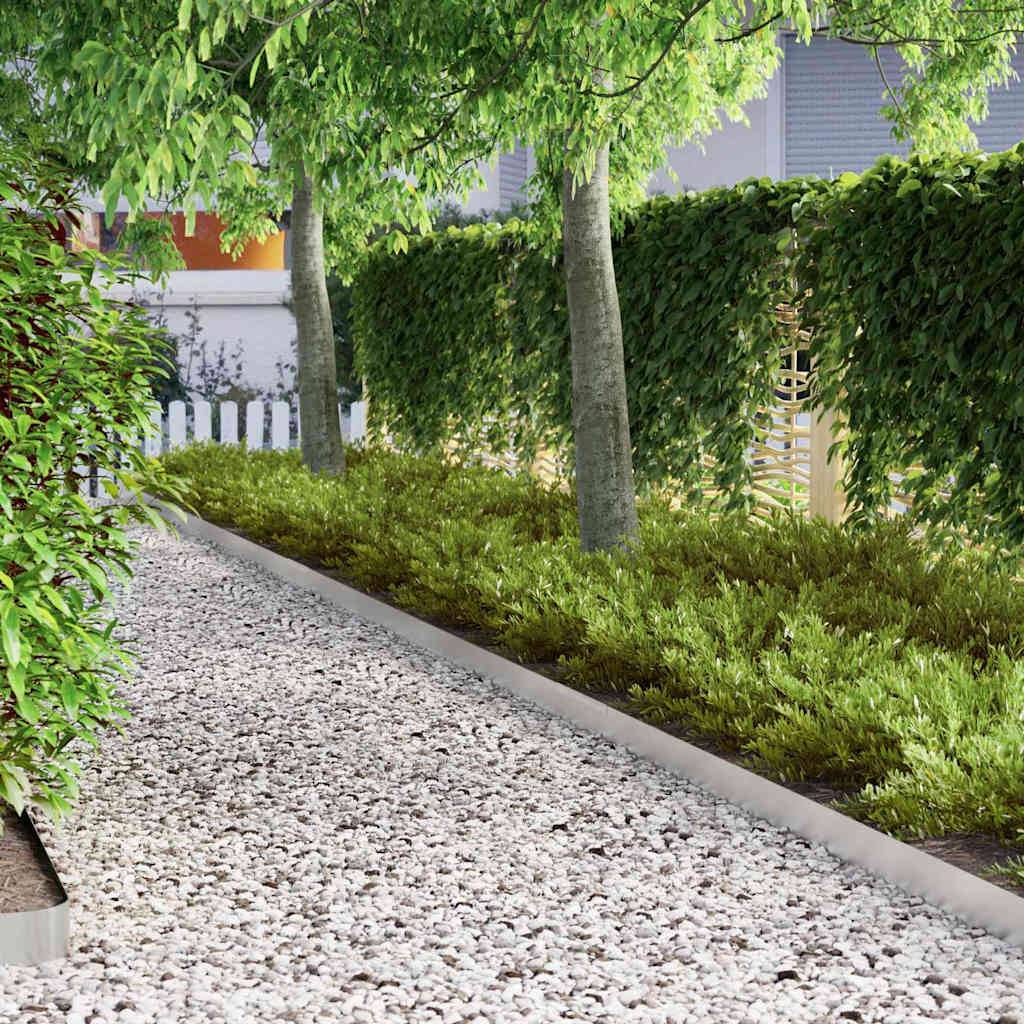 Ein Weg, gesäumt von dichtem grünem Blattwerk und Bäumen auf beiden Seiten, führt zu einem weißen Gartenzaun und schafft eine einladende, friedvolle Gartenszene.