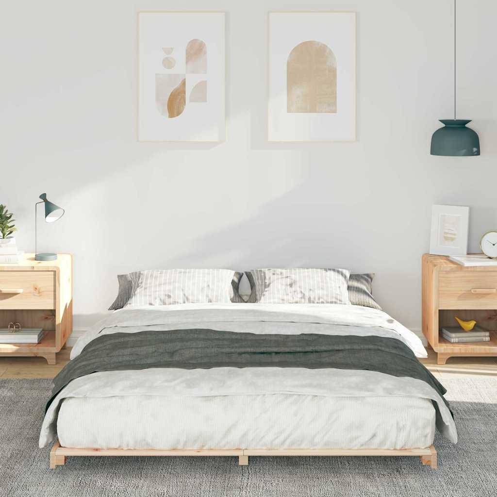 Ein ordentlich gemachtes Bett mit gestreiften Kissen und einer dunklen Decke in einem minimalistischen Schlafzimmer, flankiert von zwei Holznachttischen mit Lampen.