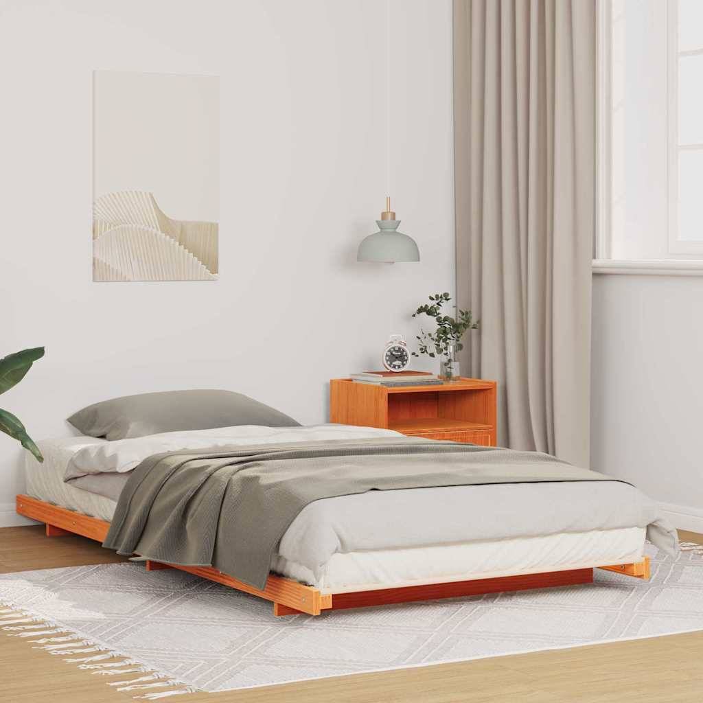 Ein minimalistisches Schlafzimmer mit einem niedrigen Holzbett, grauer Bettwäsche, einem Holznachttisch mit einer Pflanze und einer Pendelleuchte. Beige Vorhänge und ein heller Teppich vervollständigen die Dekoration.