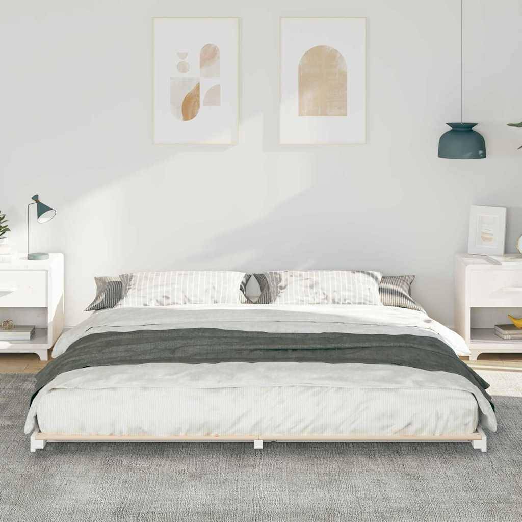 Ein minimalistisches Schlafzimmer mit einem niedrigen Bett, neutraler Bettwäsche, zwei weißen Nachttischen, Wandkunst, Pendelleuchte und Pflanzen, die eine ruhige Atmosphäre schaffen.