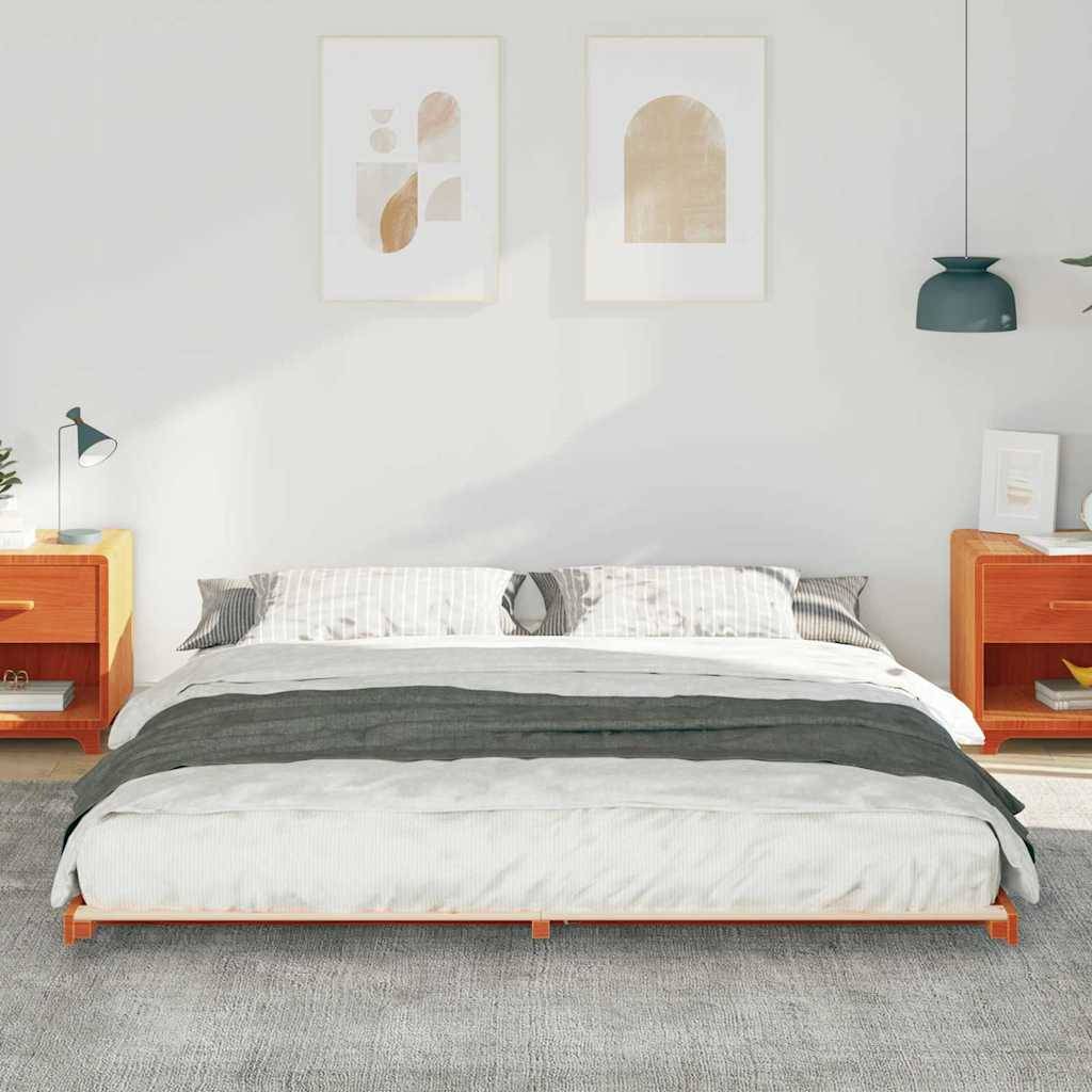 Ein ordentlich gemachtes Bett mit einem grauen und weißen Bettdeckenbezug wird von zwei Holznachttischen mit Lampen flankiert. Minimalistische Kunst hängt an der Wand darüber.