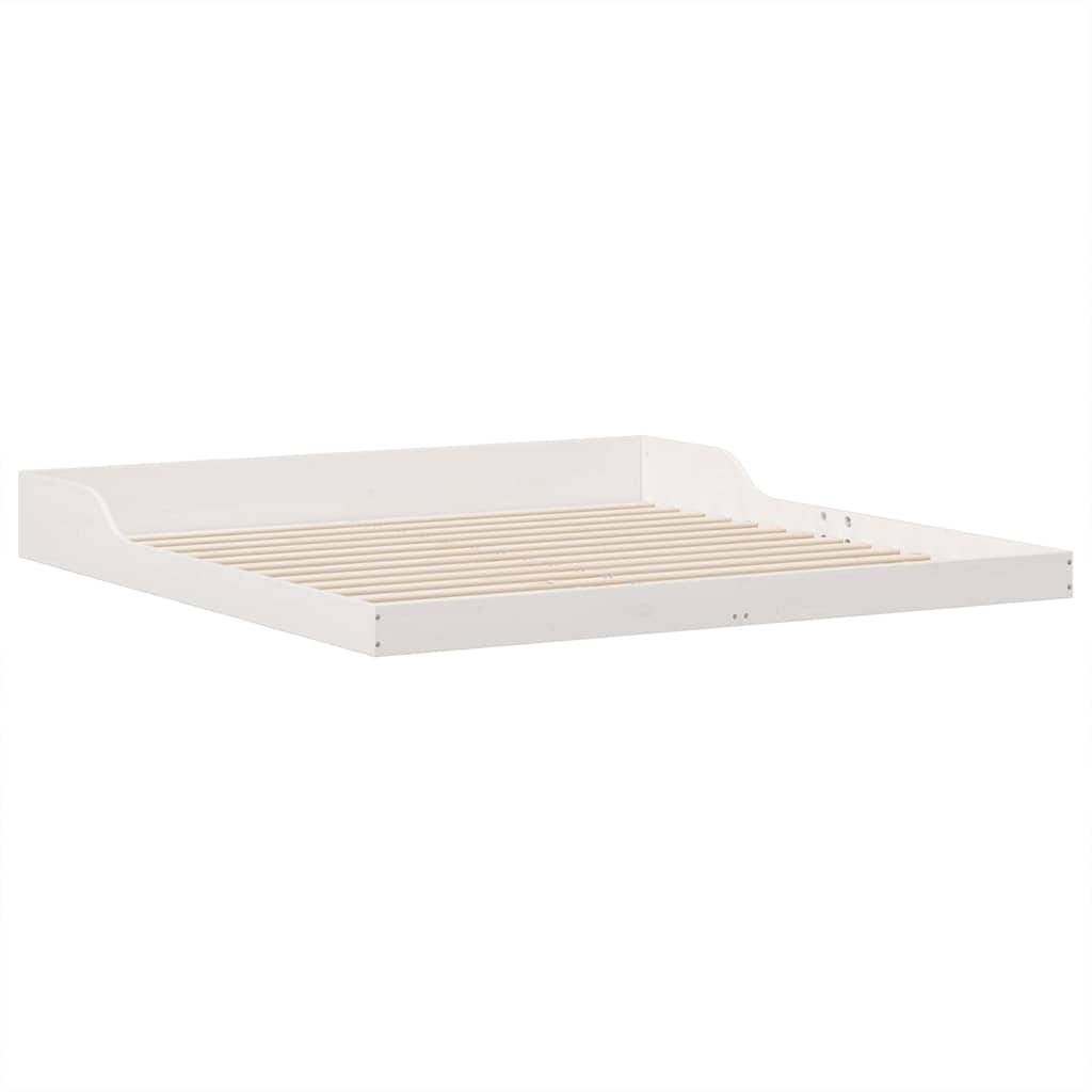 Weißer Holzbettenrahmen mit Lattenrost, aus einem Winkel betrachtet.