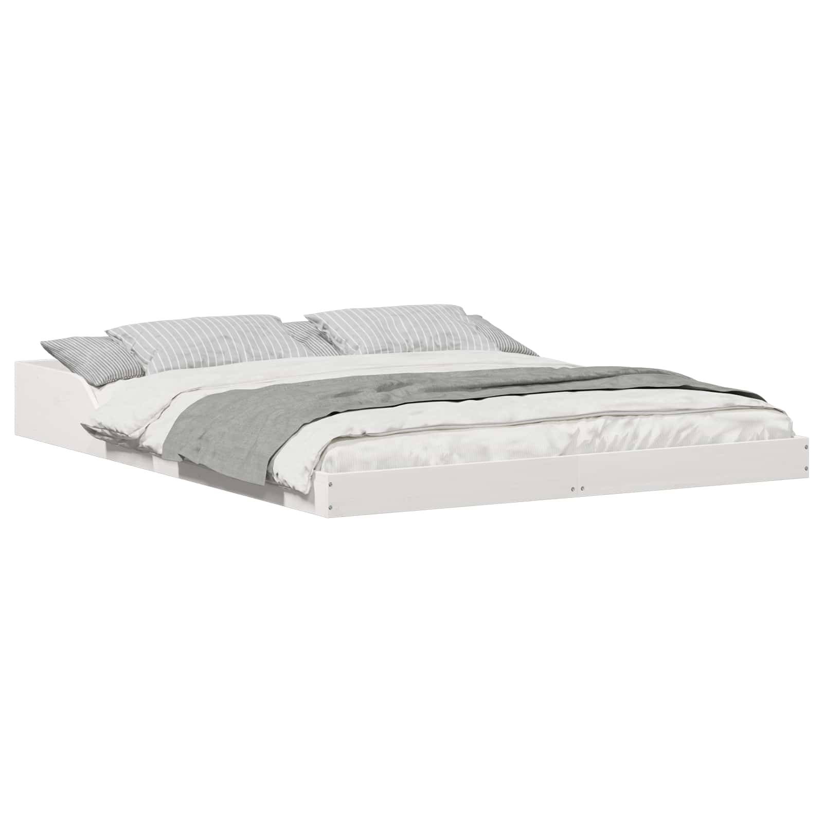 Ein weißes, niedriges Plattformbett mit zwei grau gestreiften Kissen und einer grauen Decke, die ordentlich darauf drapiert ist.