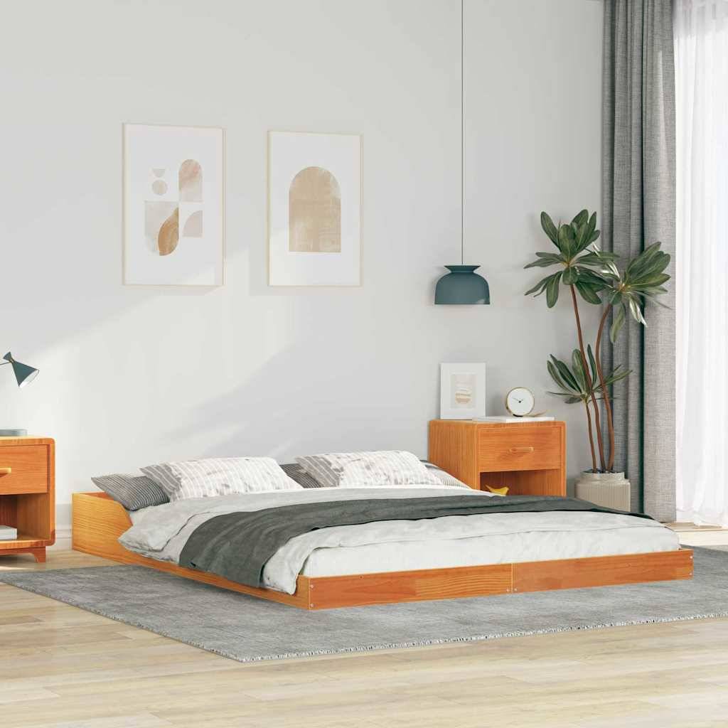 Ein modernes Schlafzimmer mit einem niedrigen Holzbett, grauer Bettwäsche und einem passenden Nachttisch. Eine Topfpflanze und abstrakte Kunst ergänzen die Dekoration.