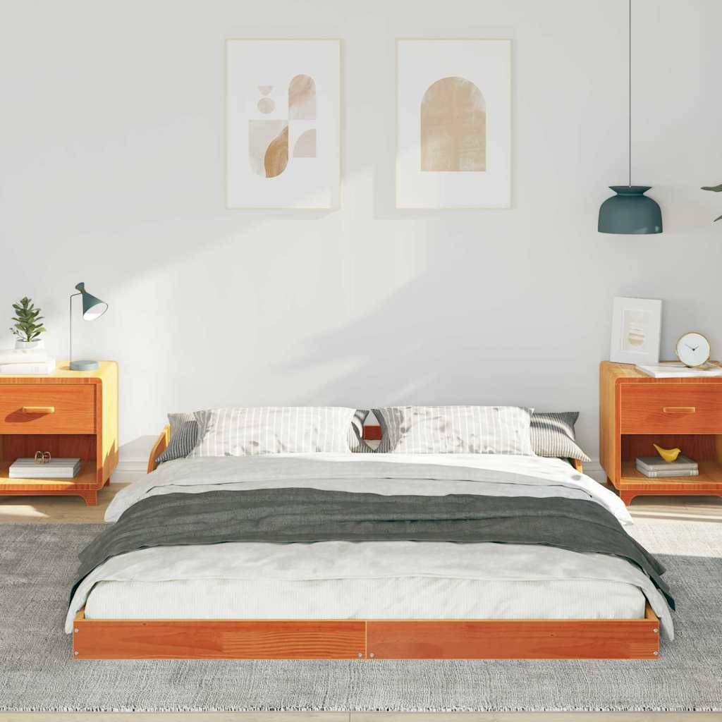 Schlafzimmer mit einem ordentlich gemachten Bett, eingerahmt von zwei Holznachttischen. Über dem Bett hängen zwei abstrakte Kunstwerke. Rechts davon befindet sich eine grüne Lampe.