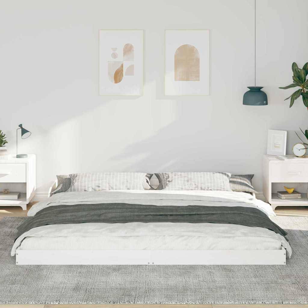 Ein ordentlich gemachtes Bett mit einem gestreiften Kissen und grauer Decke, flankiert von zwei Nachttischen, auf denen jeweils eine Lampe und kleine Dekorationsgegenstände stehen. Die Wände sind mit abstrakter Kunst geschmückt.