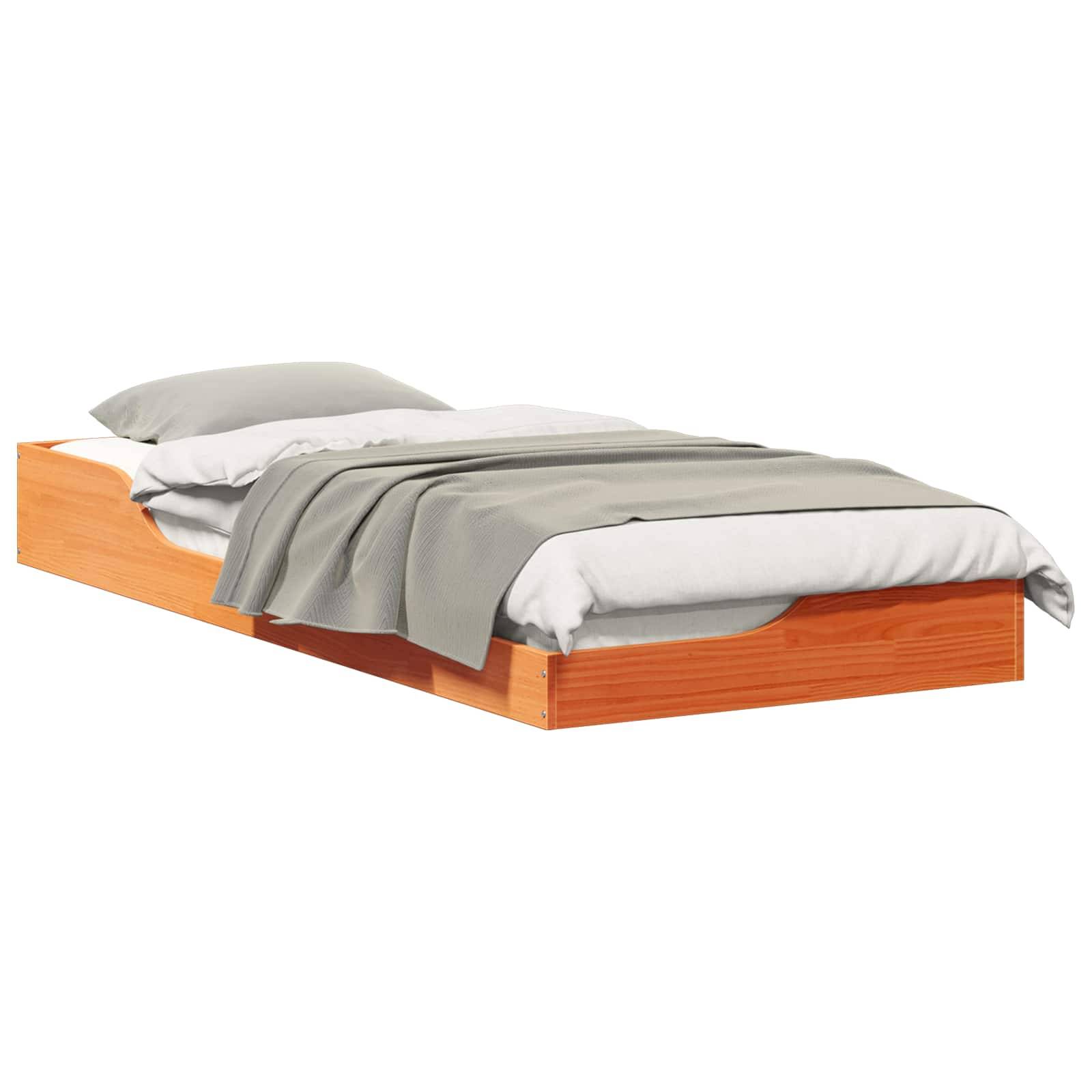 Eine Holzplattform-Bettgestell mit weißen Laken, einer grauen Decke und einem Kissen wird gezeigt. Das Bett ist bodennah.
